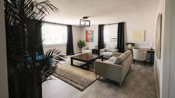 A living room with a sofa, coffee table, and a large plant. - The Overlook on Chocolate (Hershey)