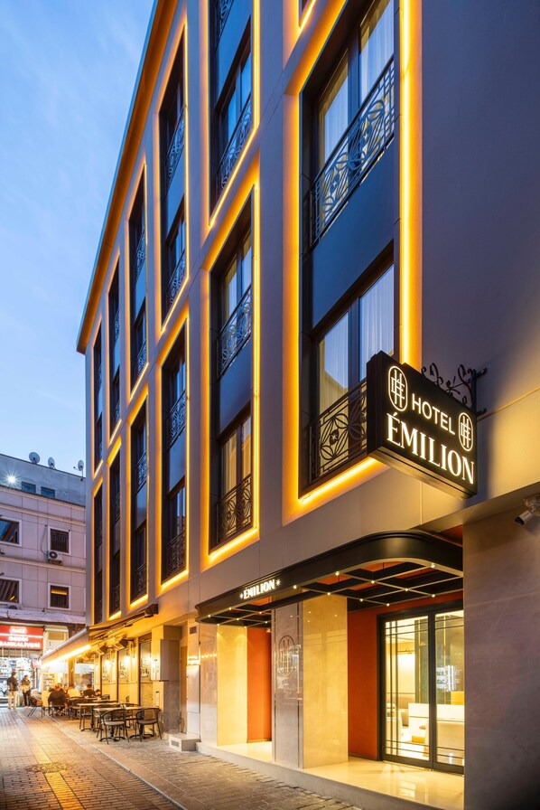 Un hotel con un letrero llamativo, ventanas amplias y un exterior bien iluminado.