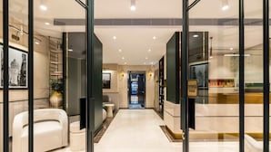 Un moderno vestíbulo de hotel con piso de mármol, un sofá, una mesita y una estantería.