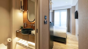 Un baño de hotel moderno con un espejo grande, un lavamanos y un inodoro.