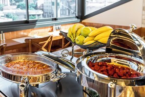 Montaje de bufé con diversos alimentos y vista al exterior.