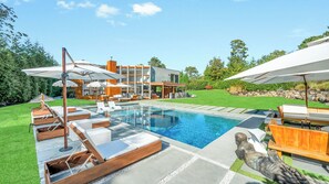 A modern house with a swimming pool, outdoor seating, and a well-maintained garden. - Modern, resort-style retreat in the heart of Shinnecock Hills, luxurious... (Southampton)