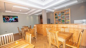 Un restaurante con mobiliario de madera y una zona de bar.