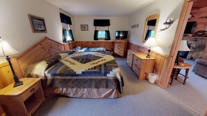 Une chambre à coucher avec un lit en bois, une commode, une table de chevet, un miroir et une petite table avec une lampe.