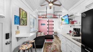 A compact kitchen with a built-in stove, a coffee maker, and a refrigerator.
