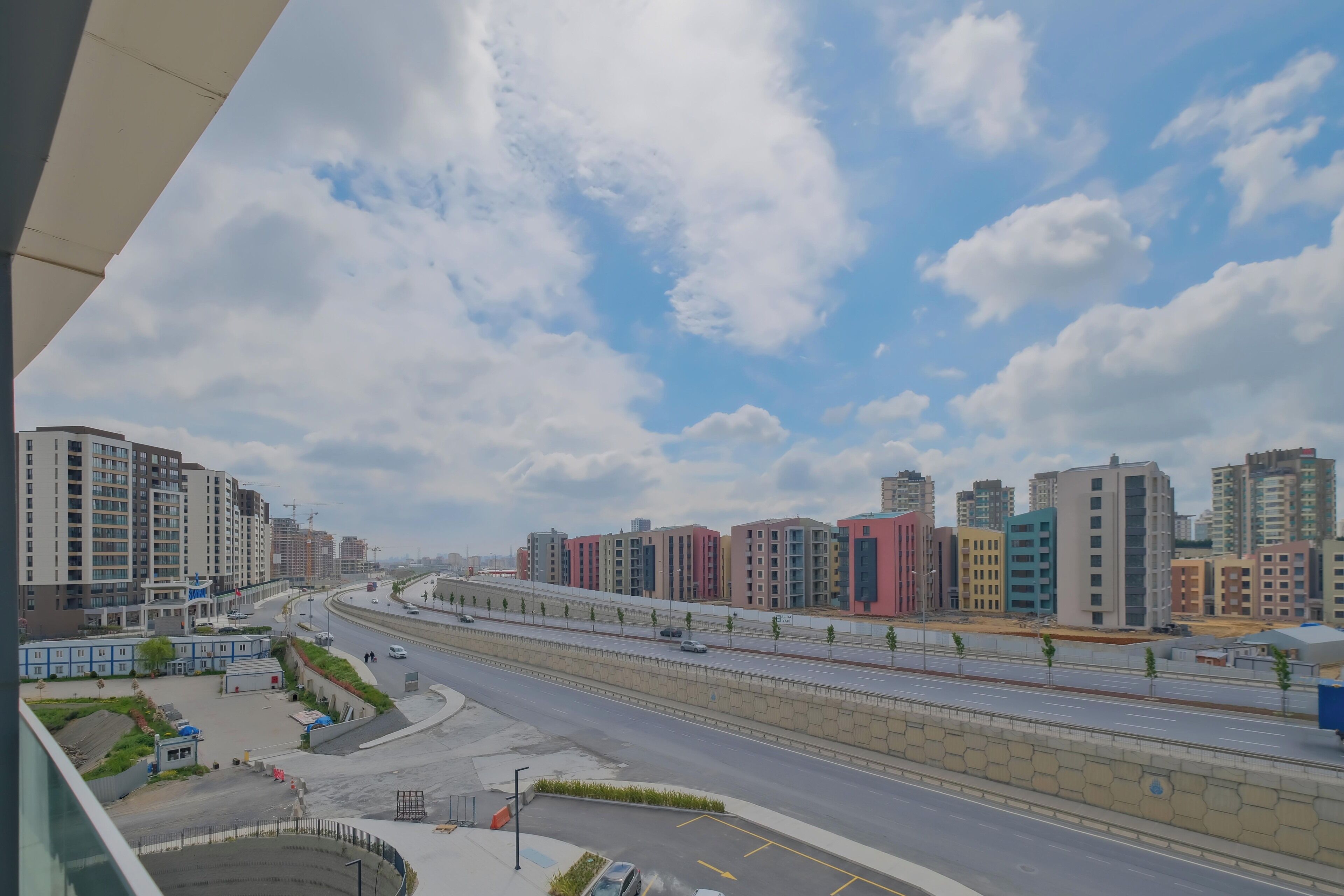 Eine moderne Stadtstraße mit mehrstöckigen Gebäuden, einer gewundenen Straße und blauem Himmel.