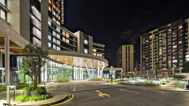A modern building with a curved glass facade and a landscaped area with a tree and plants. - Modern Furnished Apartments in Istanbul Basaksehir By Iradah Gayrimenkul (Istanbul)