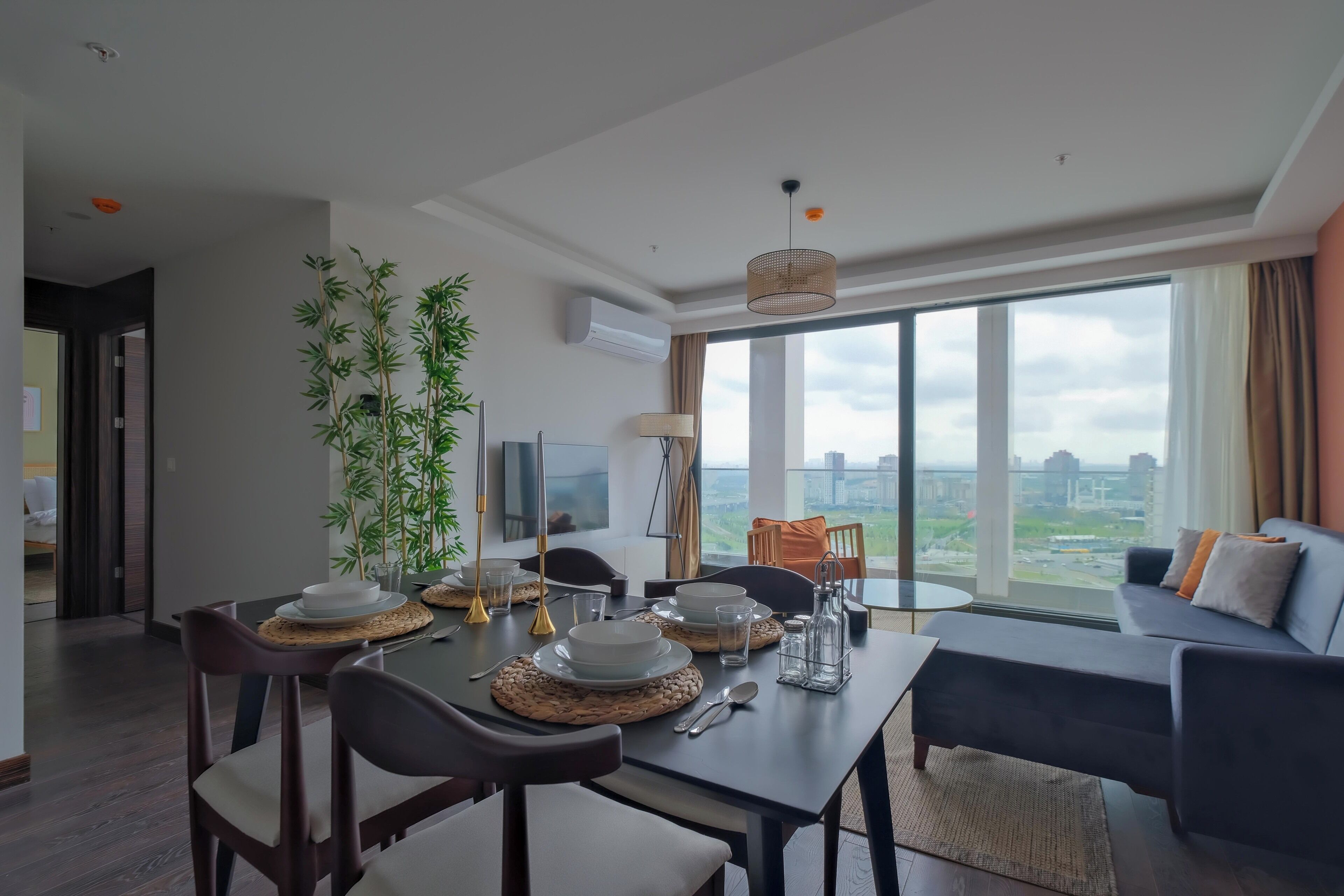 Una sala de estar moderna con comedor, ventanas amplias y vista a la ciudad.