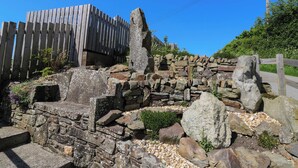 A stone wall with steps leading up to a wooden fence. - Coach House (Llandysul)