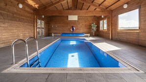 A wooden cabin with a swimming pool, large windows, and a bench. - Coach House (Llandysul)