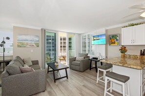 Relax in a stylish living space with a sofa, armchairs, and a kitchen area.