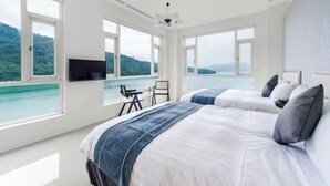 A bedroom with two beds, large windows, a television, and a view of a lake. - Shui Yang Lakeview House with Elevator (Nantou)