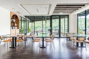 A spacious room with a long table and chairs, large windows, and a view of greenery. - Shui Yang Lakeview House with Elevator (Nantou)