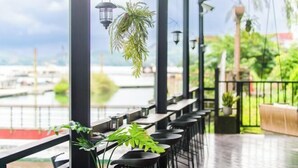 A covered outdoor seating area with tables and chairs, potted plants, and hanging lanterns. - Shui Yang Lakeview House with Elevator (Nantou)