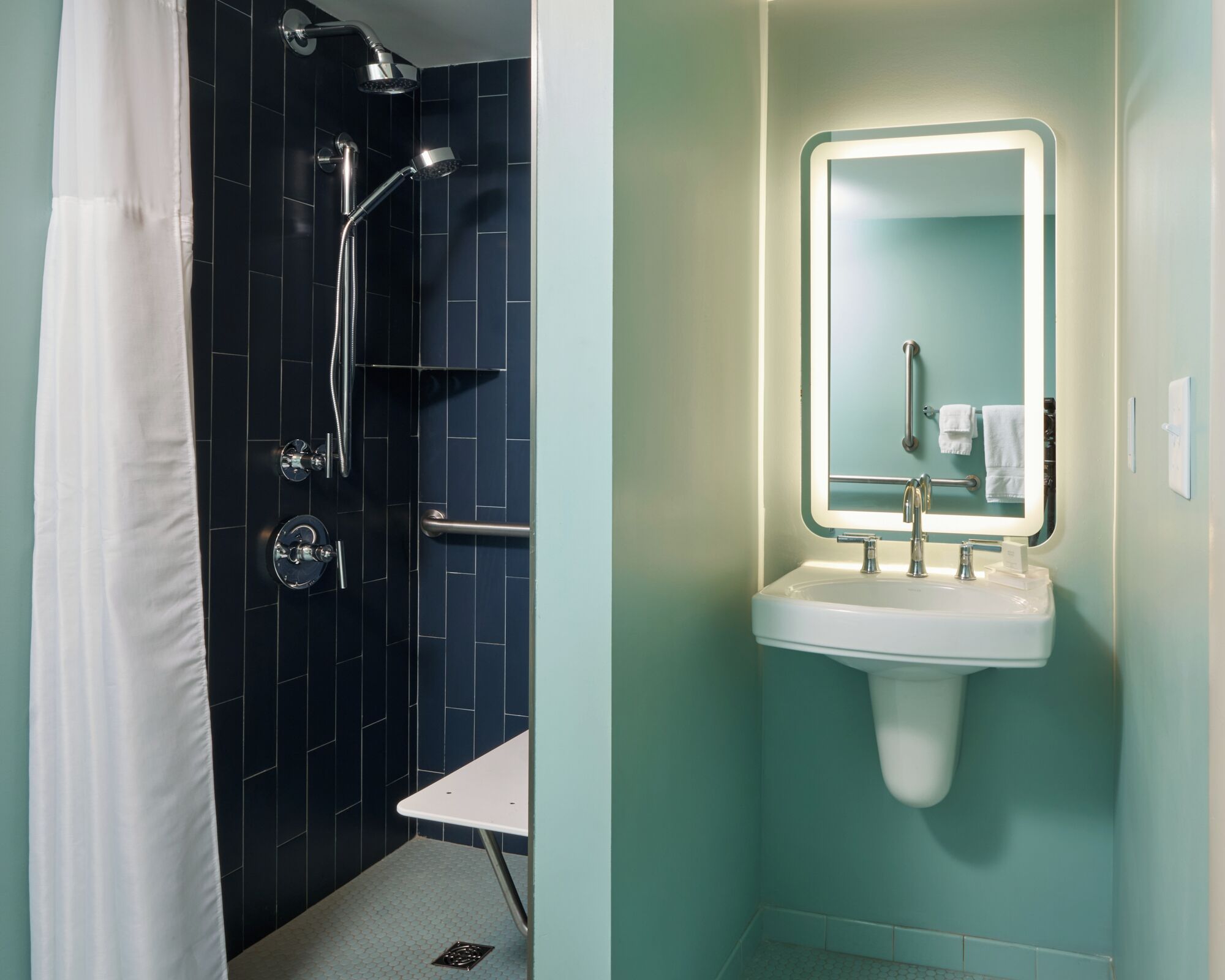 A bathroom with a shower, a sink, and a mirror.