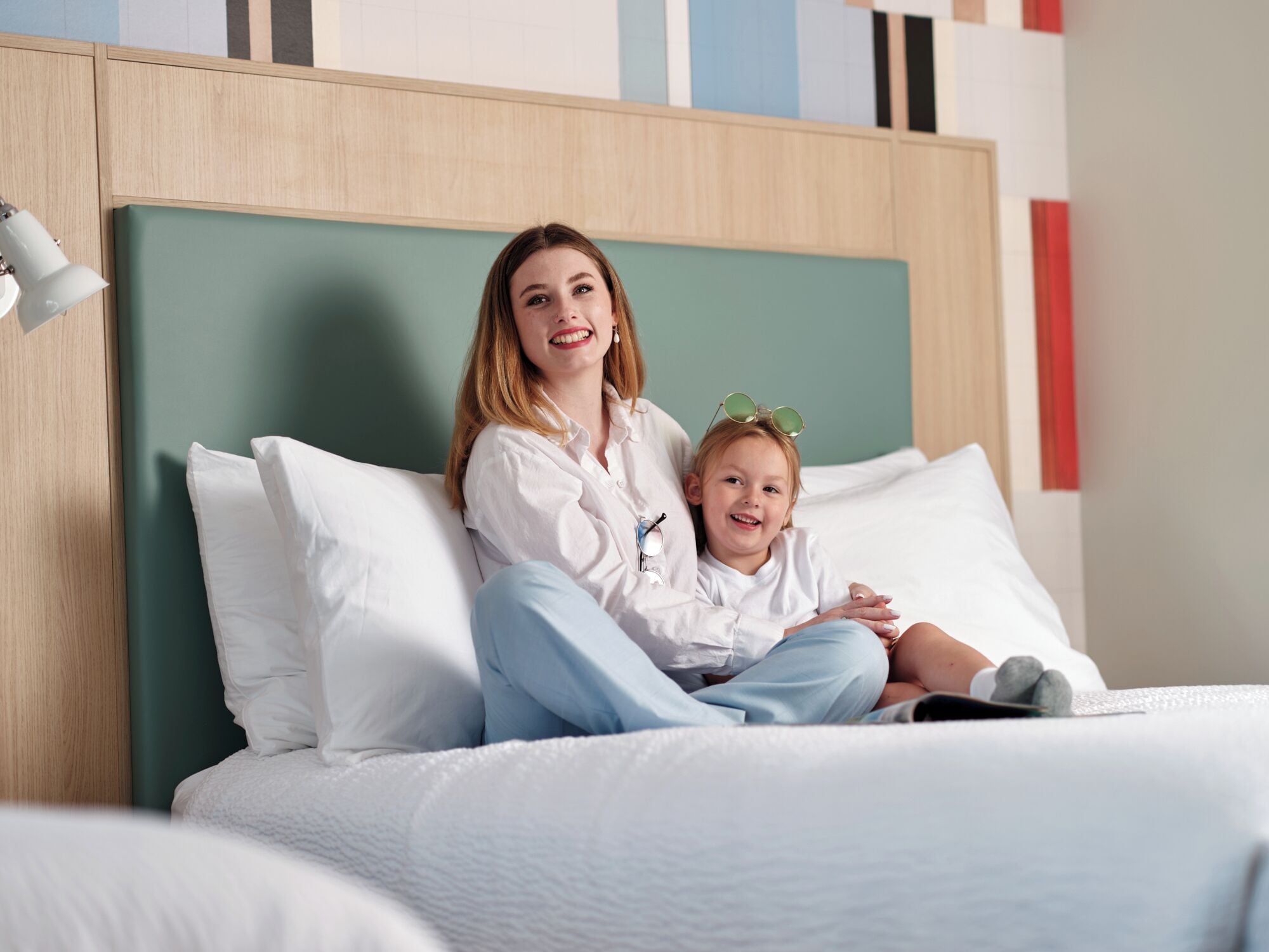 A bed with white bedding and a wooden headboard.