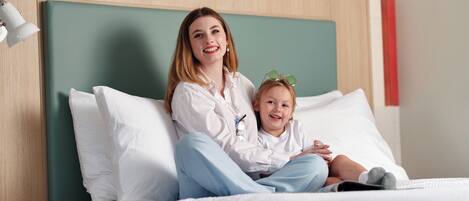 A bed with white bedding and a wooden headboard.