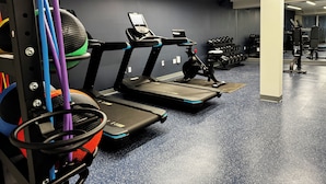 A gym with treadmills, weight machines, and a rack of dumbbells. - Colony House Motor Lodge (Roanoke)