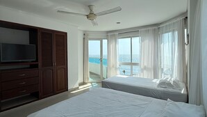 A hotel room with a large bed, a TV, a wardrobe, and a balcony with a view of the sea. - APARTAMENTO 702A (Cartagena)