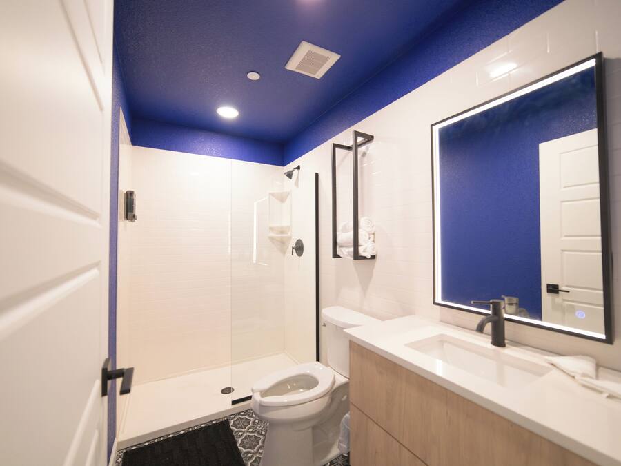 Un bagno moderno con il water bianco, un lavabo e uno specchio.