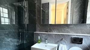 A modern bathroom with a glass-enclosed shower, a white sink with a soap dispenser, and a toilet. - Central London Apartment With 2 Bedrooms -sleeps 6 (London)
