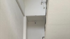 A staircase with a metal railing, white walls, and a plain ceiling. - Hospedagem Praia do Forte (Tamandaré)