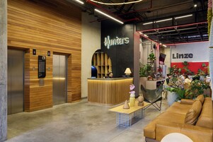 A reception area with a wooden reception desk, a reception counter, a sign for 'Hunters', and a 'Linze' sign.