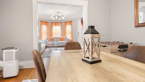 A dining area with a wooden table, chairs, a foosball table, and a ceiling fan. - Modern 2BR • Mins to Univ, Zoo, Destiny & Downtown (Syracuse)