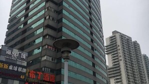 Een meerlaags gebouw met een opvallend Haixing Plaza bord op de begane grond.