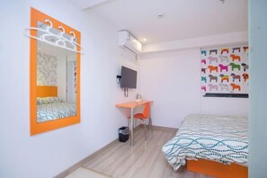 A compact room with a bed, a desk, a chair, a television, and a wall-mounted air conditioning unit. - Pod Inn (Shanghai Ruijin Hospital Dapuqiao Metro Station) (Shanghai)