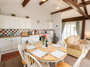 A compact living space with a kitchen, dining area, and a sofa. - Swallows (Ventnor)