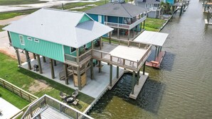 Een pand aan het water met meerdere terrassen, een overdekte buiten zitplaats en uitzicht op het water.