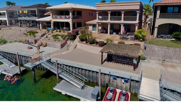 A coastal hotel with multiple buildings, a dock with boats, and a beach area. - Riverfront Luxury: 4BR Retreat w/ Dock, Launch, Endless Views, Colorado Oasis (Mohave Valley)