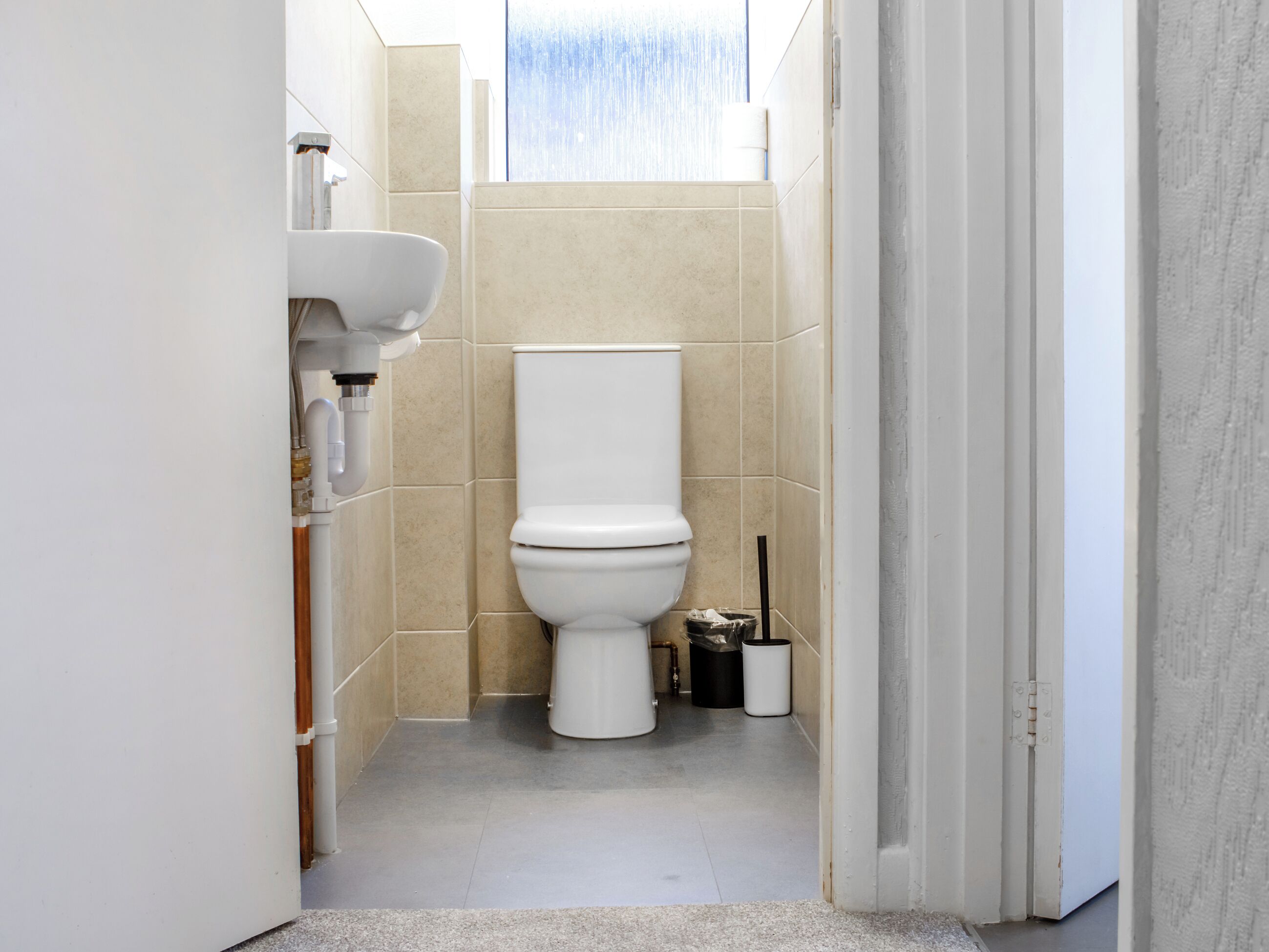 Un baño moderno con inodoro, lavamanos y zona de ducha.