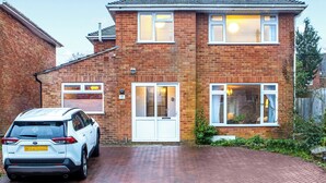 A two-story brick house with a driveway, a white car parked in the driveway, and a visible number '11' on the house. - 4 bedroom accommodation in Salisbury, near Dorset (Salisbury, near Dorset)