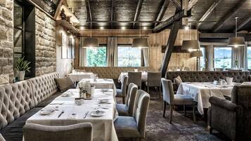 Un restaurante con una larga mesa de comedor, asientos acolchados y una decoración rústica.