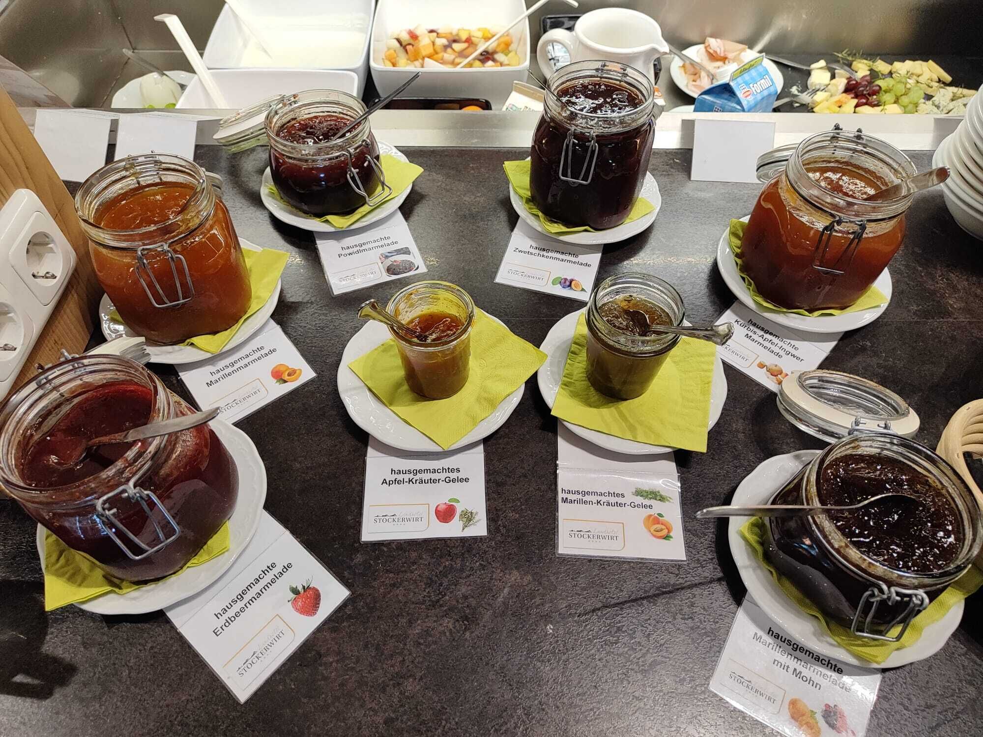 Una exhibición de mermeladas caseras en platos con etiquetas que indican distintos sabores.