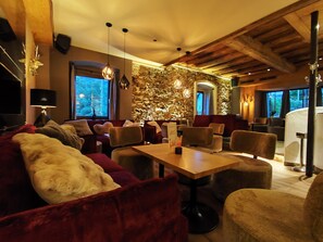 A cozy interior with a stone wall, plush seating, and pendant lighting. - Landhotel das Stocker (Vorderstoder)