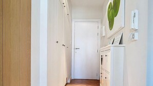 A hallway with wooden flooring, white walls, and a door at the end. - Cosy Sunny Apartment Near Zeedijk (Knokke-Heist)