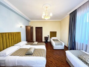 Habitación de hotel con dos camas, un escritorio, una silla y una araña.