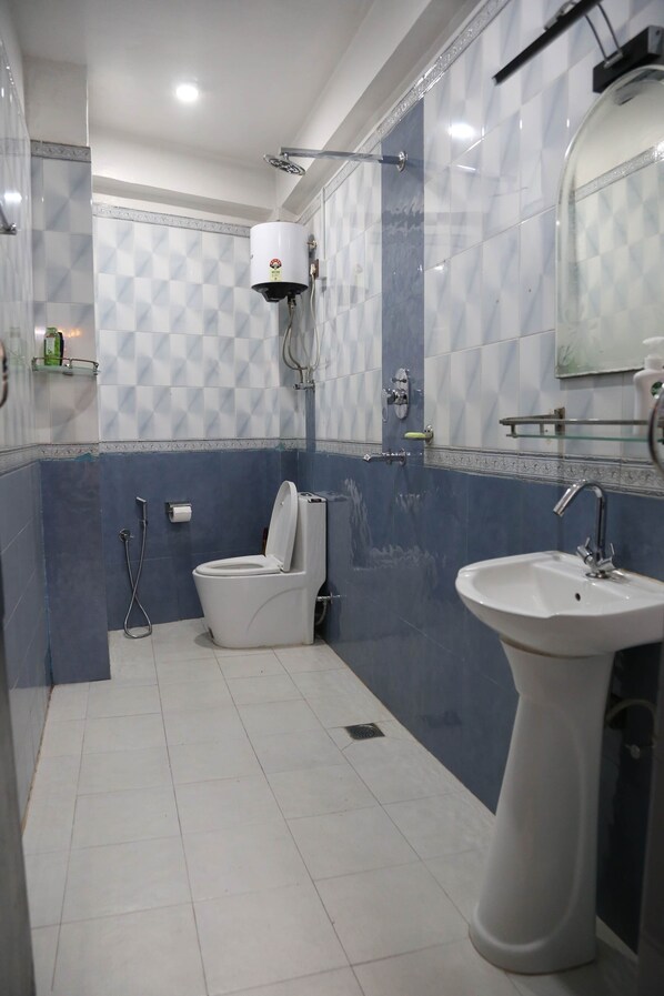 Une salle de bain avec des toilettes, un lavabo et une douche.