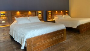 Habitación de hotel con dos camas de madera, cada una con cabecero de diseño geométrico e iluminación integrada.