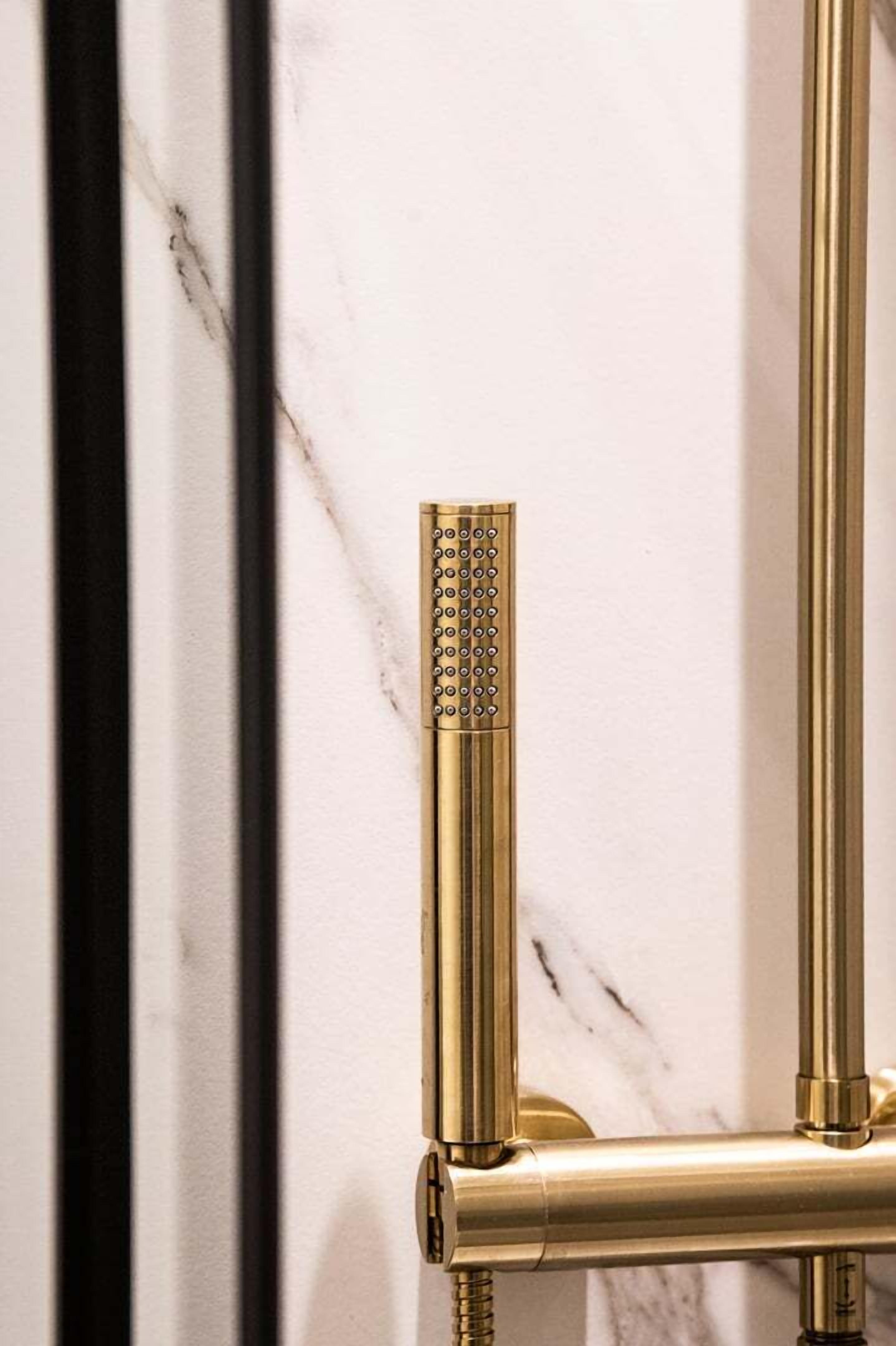 A gold-colored showerhead with a rain shower feature, mounted on a wall with a marble-like texture.
