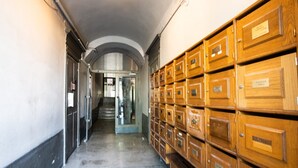 A hallway with a series of wooden filing cabinets on one side and a staircase leading to another area. - Lassagne - 2 - New studio in the city center (Lyon)