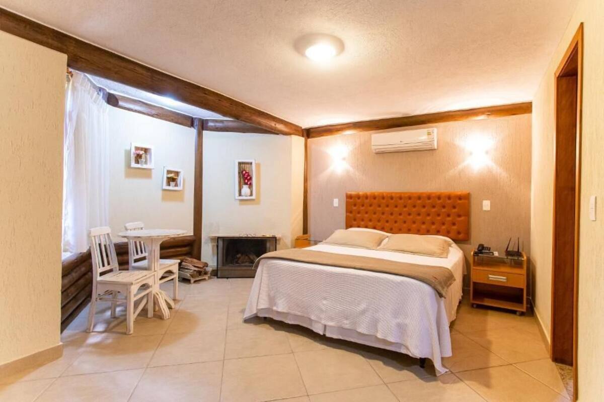 A bedroom with a bed, bedside table, and a small table with chairs.