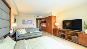 A hotel room with a large bed, a sofa, a TV, and a kitchenette. - Ocean View Luxury Studio @ Brickell-DWTN Miami (Miami)