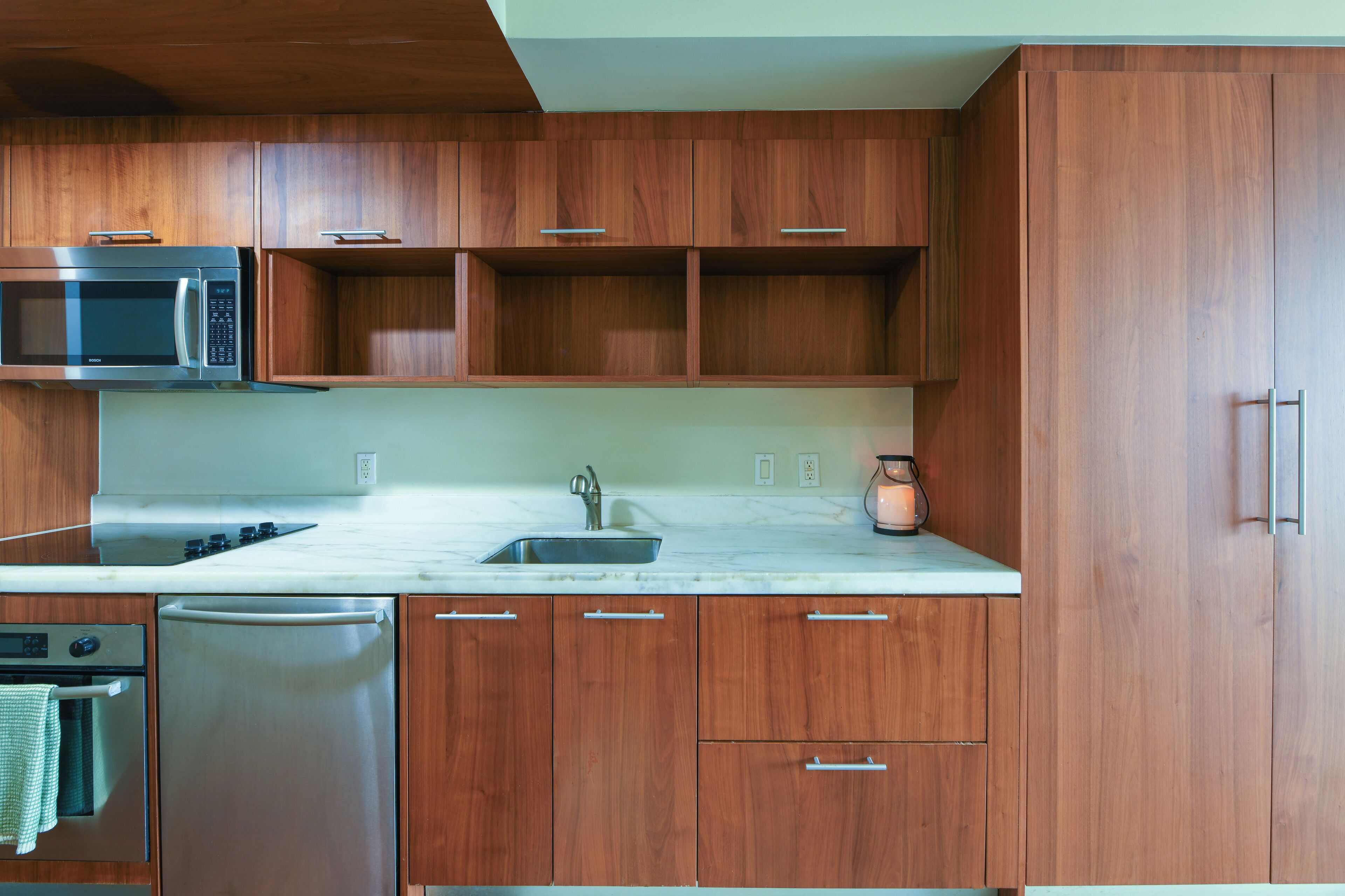 A kitchen with wooden cabinets, a stainless steel microwave, a dishwasher, and a sink.