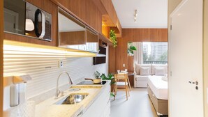 A modern kitchen with a built-in oven, a sink, and a dining area with a table and chairs. - Today Pinheiros NR (Sao Paulo)