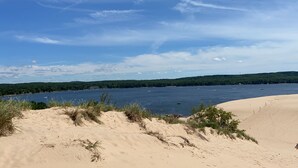 Ein Strand mit Dünen und einem See.