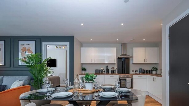 A modern kitchen with white cabinets, a built-in oven, and a stainless steel range hood. - Luxury Waterfront 2BR - Free Gym Access & Parking (Stretford)